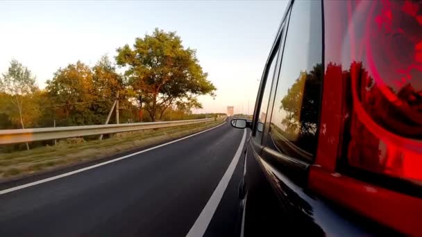 Conduire une voiture à travers le pont. La caméra est laissée dehors. Heure du coucher du soleil . — Video