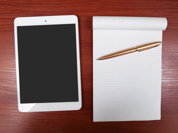 Ipad mini white and notepad on wood table. — Stock Photo, Image