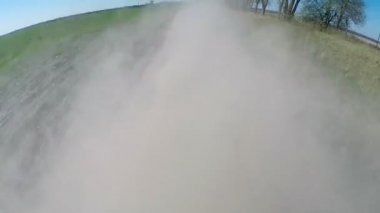 Kırsal tozlu yolda sürüş. Kamera dışında ve geri amaçlayan.