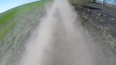 Kırsal tozlu yolda sürüş. Kamera dışında ve geri amaçlayan.