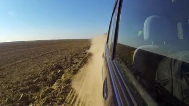 Kırsal kesimde bir araba hızlı. Kamera dışında ve geri amaçlayan.
