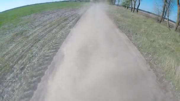 Rijden op landelijke stoffige weg. De camera is buiten en gericht terug. — Stockvideo