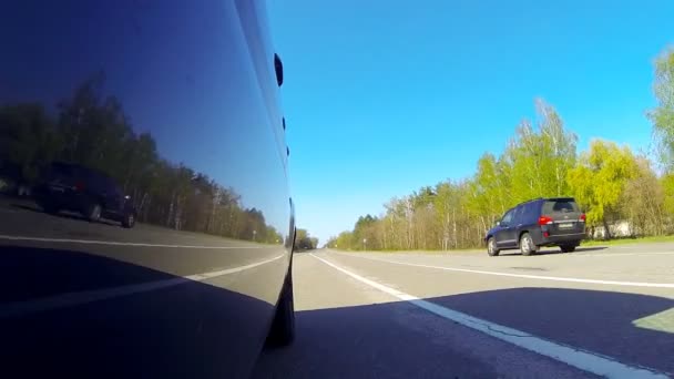 Conduire une voiture. La caméra est à l'extérieur et dirigée vers l'arrière . — Video