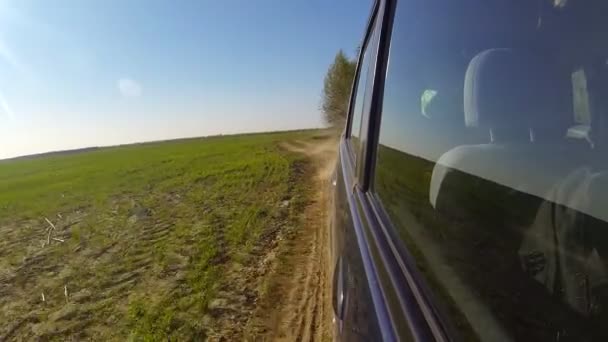 Conduce rápido un coche en el campo. La cámara está fuera y apuntó hacia atrás . — Vídeo de stock