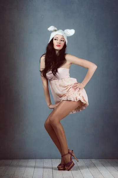 Beautiful sexy woman with long silky hair posing, girl in the image of the rabbit in  pink dress bad bunny sly sexy look play boy for men — Stock Photo, Image