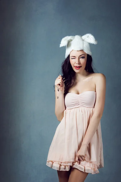 Mooie sexy vrouw met lang zijdeachtig haar poseren, meisje in het beeld van het konijn in roze jurk slechte bunny sluwe sexy blik play boy voor mannen — Stockfoto