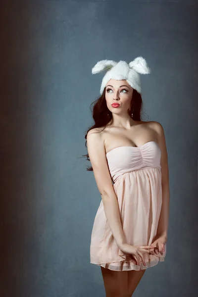 Mooie sexy vrouw met lang zijdeachtig haar poseren, meisje in het beeld van het konijn in roze jurk slechte bunny sluwe sexy blik play boy voor mannen — Stockfoto