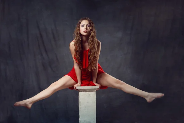 Jeune belle et charmante fille en rouge danse avec une silhouette mince danseuse de corps en plastique avec gymnaste cheveux effectue ficelle bouclée annulaire — Photo