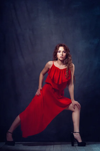 Young beautiful and charming girl in red is dancing with a slender figure plastic body dancer with hair gymnast performs twine curly ringlet — Stock Photo, Image