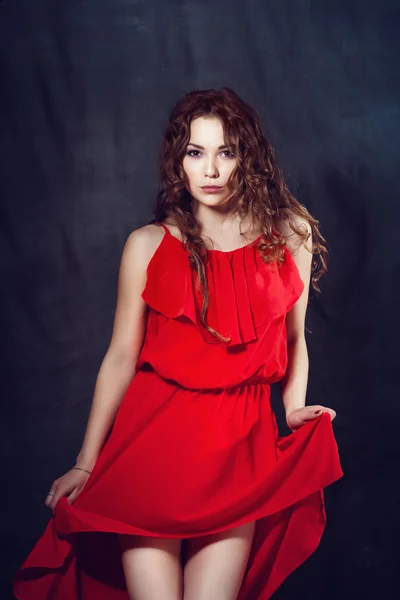 Young beautiful and charming girl in red is dancing with a slender figure plastic body dancer with hair gymnast performs twine curly ringlet — Stock Photo, Image