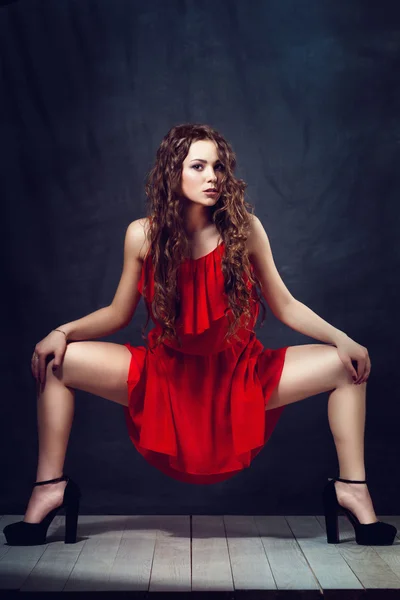 Joven hermosa y encantadora chica en rojo está bailando con una figura esbelta bailarina de cuerpo de plástico con gimnasta de pelo realiza —  Fotos de Stock