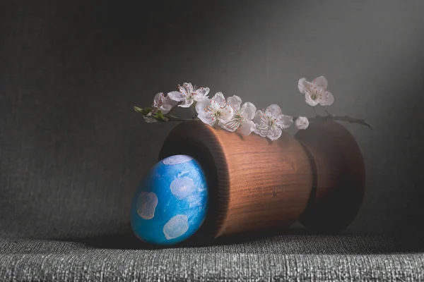 Uovo azzurro in piselli bianchi con ramo l'albero fiorente in un mortaio — Foto Stock