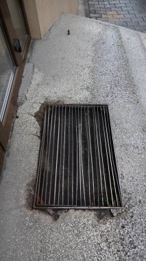 Yıpranmış beton bir yüzeyde kentsel metal ızgara