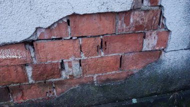 Hasarlı duvar alçısının altındaki tuğlalar..