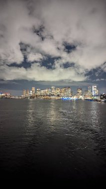 Şehir geceleri gökyüzüne yükselir ve suyu yansıtır.