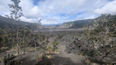 Bulutlu bir gökyüzünün altında engin volkanik manzara