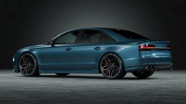 Stüdyo ortamında modern tasarımı olan parlak mavi bir sedan.