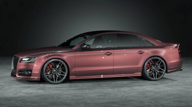 Siyah tekerlekleri olan parlak kırmızı bir sedan..