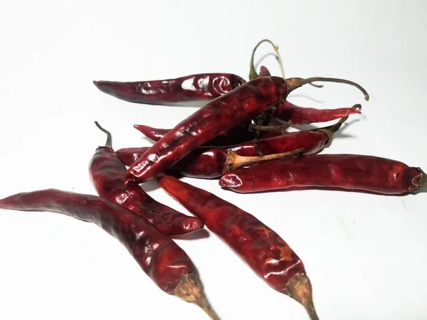 Beyaz bir yüzeye izole edilmiş kuru kırmızı biber yakın plan.