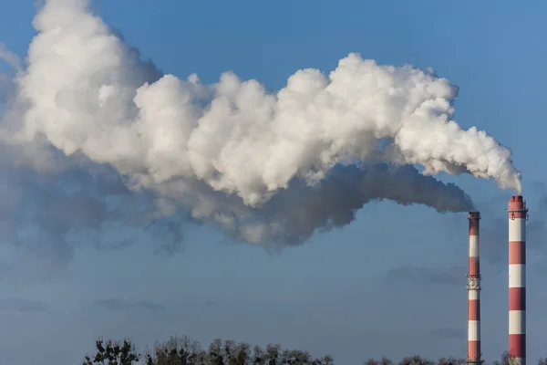 Dos chimeneas grandes con nubes de humo dramáticas . — Foto de Stock