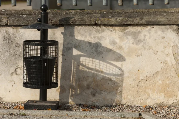 Schwarzer Mülleimer in der Nähe der Mauer. — Stockfoto