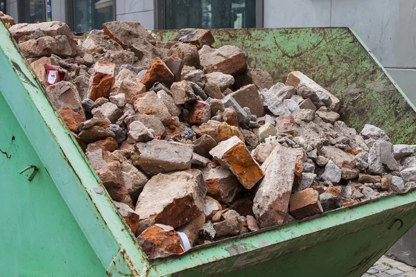 Escombros en un recipiente de metal verde . —  Fotos de Stock