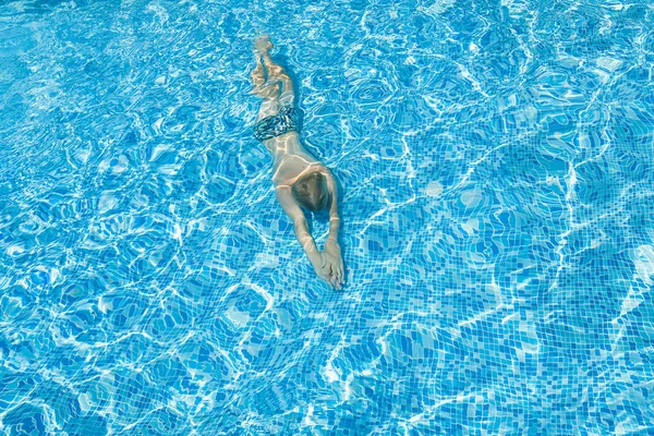 Silueta de una persona nadando en la piscina . — Foto de Stock