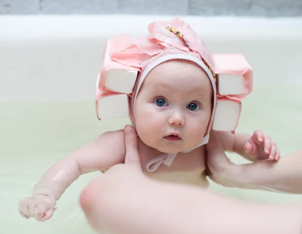 Bebé con gorra de natación en el baño en brazos de su madre — Foto de Stock