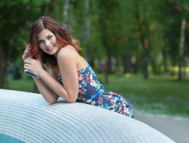 Çeşme, mavi elbiseli genç gülümseyen kahverengi saçlı kadın