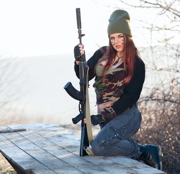 Sexy Frau mit einer Waffe im Freien — Stockfoto