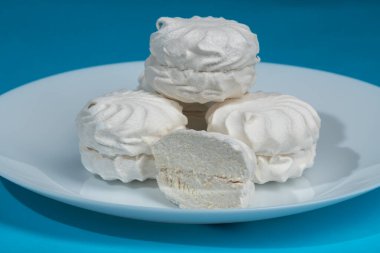 Mavi arka planda beyaz, kabarık, havadar şekerlemeler..