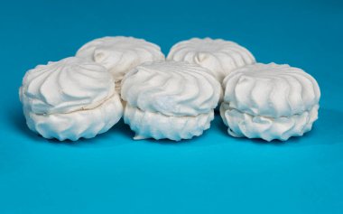 Mavi arka planda beyaz, kabarık, havadar şekerlemeler..