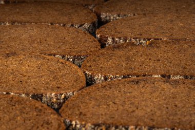 Tahtada dilimlenmiş çavdar ekmeği ve siyah bir arka plan.