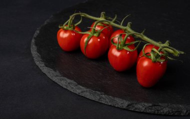 Siyah arka planda küçük domatesler.