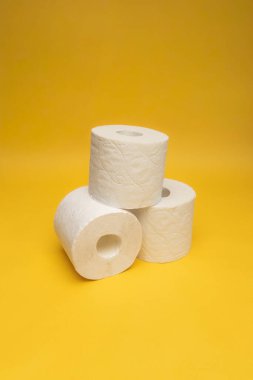 Tuvalet kağıdı sarı arka planda yuvarlanıyor..