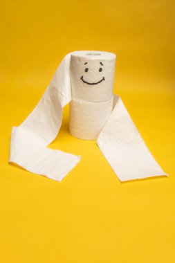 Tuvalet kağıdı sarı arka planda yuvarlanıyor..
