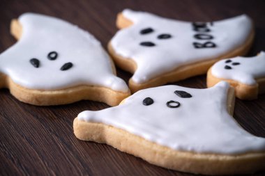 Tatlı Cadılar Bayramı hayaletli zencefilli kurabiyeleri krema soslu poşetle süsleyin..