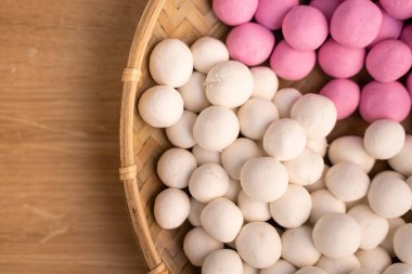 Tahta bir masanın üzerinde saf kırmızı ve beyaz tangyuan, kış gündönümü festivali için yiyecek hazırlama kavramı..