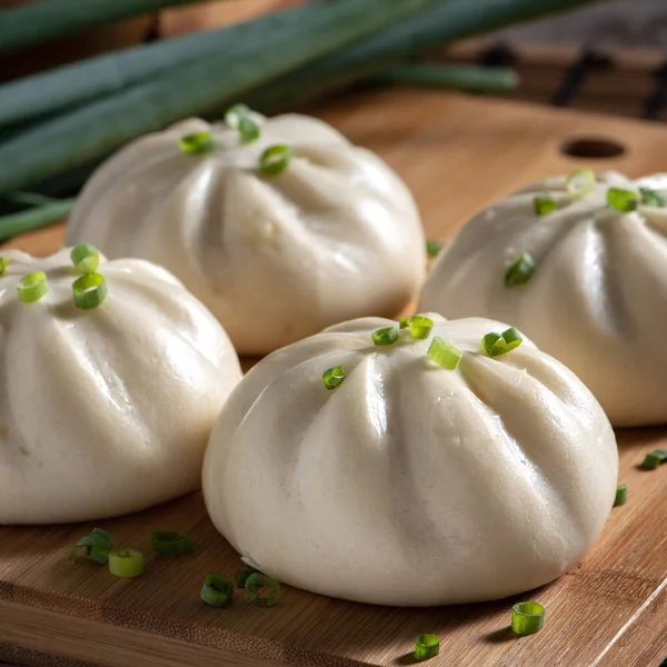 Close up of fresh delicious baozi, Chinese steamed meat bun is ready to eat on serving plate and steamer, close up, copy space product design concept.