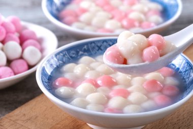 Kırmızı ve beyaz tangyuan 'ı (tang yuan, glutinous rice dumpling balls) kış gündönümü festivali için ahşap zemin üzerinde mavi kasede kapatın..