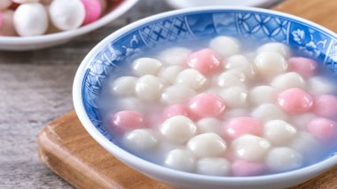 Kırmızı ve beyaz tangyuan 'ı (tang yuan, glutinous rice dumpling balls) kış gündönümü festivali için ahşap zemin üzerinde mavi kasede kapatın..