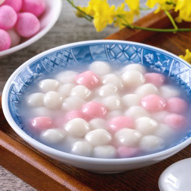 Kırmızı ve beyaz tangyuan 'ı (tang yuan, glutinous rice dumpling balls) kış gündönümü festivali için ahşap zemin üzerinde mavi kasede kapatın..