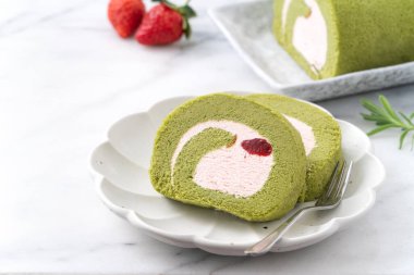 Lezzetli kirazlı rulo pasta dilimleri beyaz arka planda çilekli krema, yakın plan..