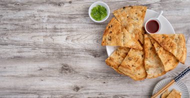 Tayvan yemeği. Parlak ahşap masa arkaplanında leziz pullu gözleme. Tayvan 'da geleneksel atıştırmalıklar..