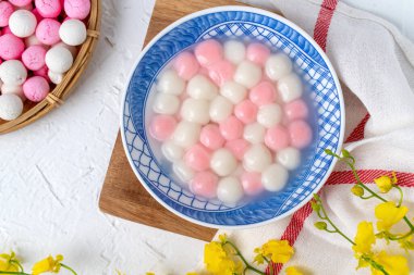Kırmızı ve beyaz tangyuan 'ın (tang yuan, glutinous rice dumpling balls) beyaz arka planda kış gündönümü festivali yemekleri için mavi kasede.