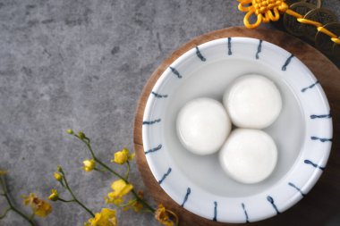Yeni yıl festivali yemekleri için büyük tangyuan yuanosunun (glutinous rice dumpling balls) en üst görüntüsü, altın sikkenin üzerindeki kelimeler onun yaptığı hanedan adı anlamına gelir..
