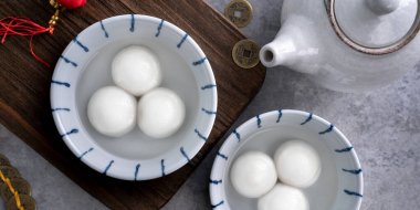 Yeni yıl festivali yemekleri için büyük tangyuan yuanosunun (glutinous rice dumpling balls) en üst görüntüsü, altın sikkenin üzerindeki kelimeler onun yaptığı hanedan adı anlamına gelir..