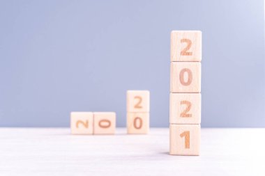 2021 Yeni Yıl Soyut Tasarım Konsepti - Ahşap masa üzerinde izole edilmiş tahta blok küpleri ve açık mavi arka plan.