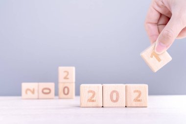 2021 Yeni Yıl Soyut Tasarım Konsepti - Ahşap masa üzerinde izole edilmiş tahta blok küpleri ve açık mavi arka plan.