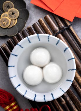 Yeni yıl festivali yemekleri için büyük tangyuan yuanosunun (glutinous rice dumpling balls) en üst görüntüsü, altın sikkenin üzerindeki kelimeler onun yaptığı hanedan adı anlamına gelir..
